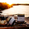 Jar of Sol Shield on a wooden tray outside with some supporting ingredients like Tallow